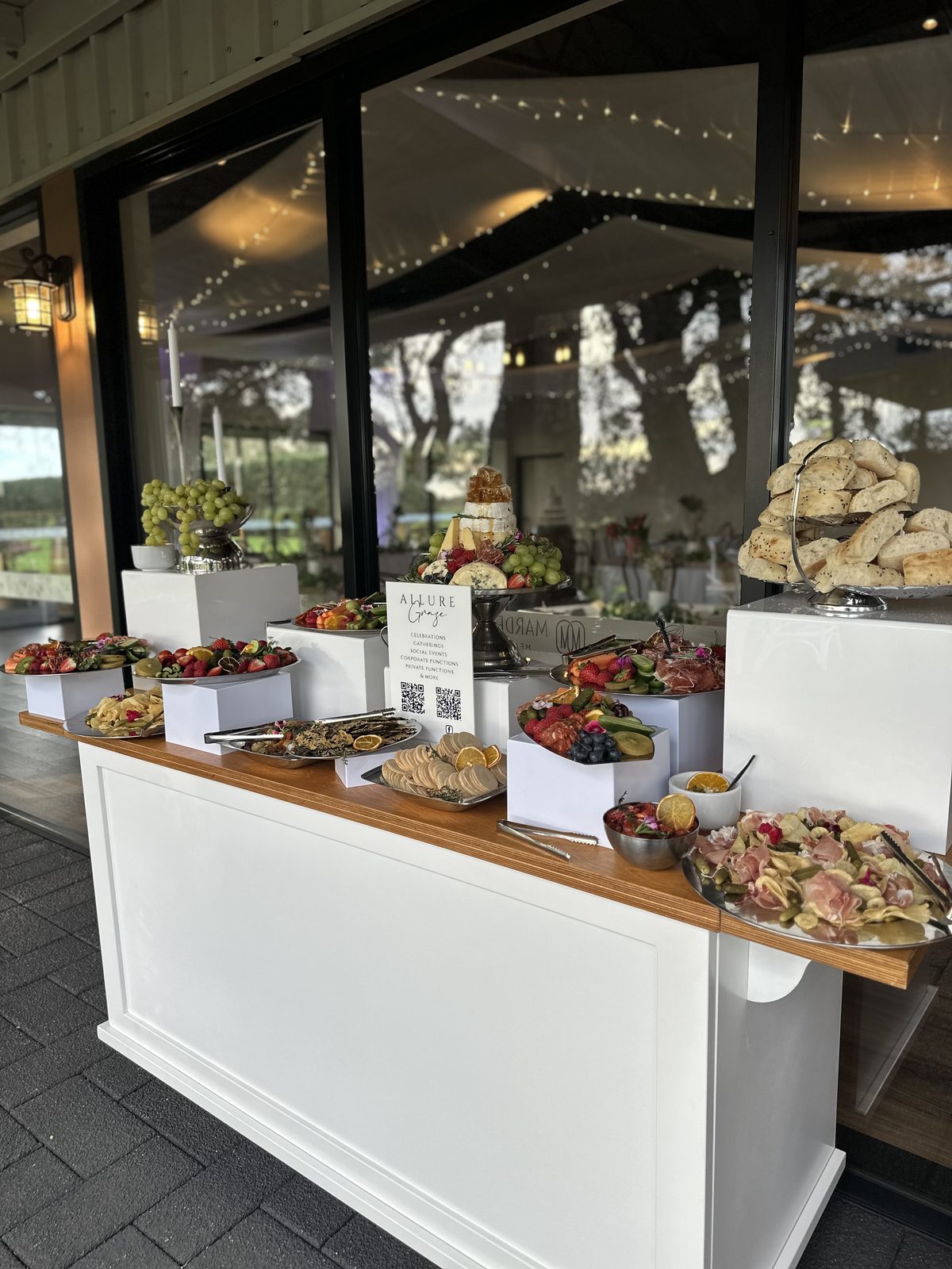 Grazing cart laden with charcuterie, cheese and fruit at a wedding cocktail hour